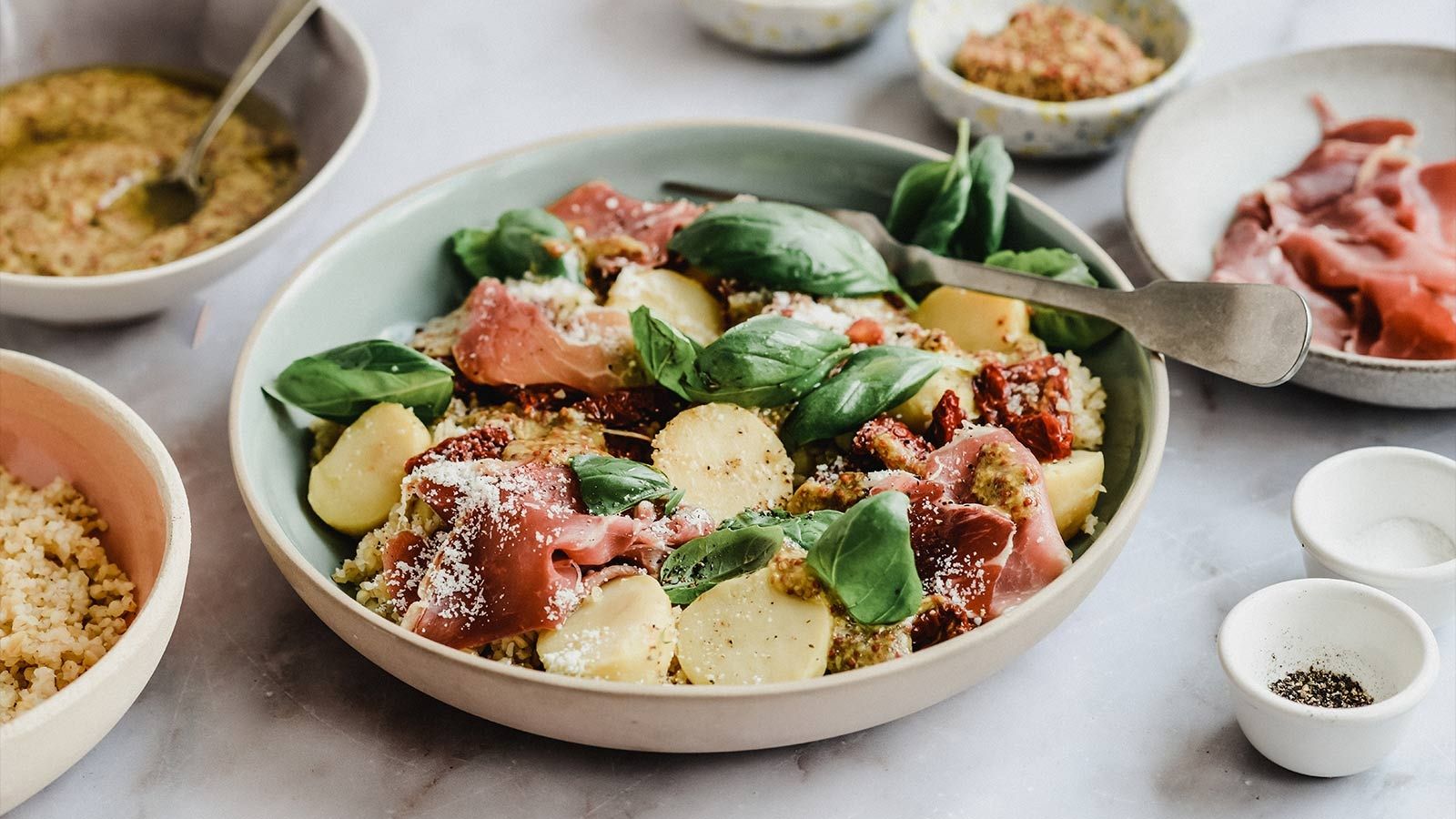 Sałatka ziemniaczana z kaszą bulgur, suszonymi pomidorami, bazylią, parmezanem i szynką serrano